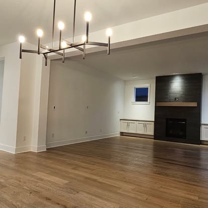 Open living room with a fireplace and wood floors